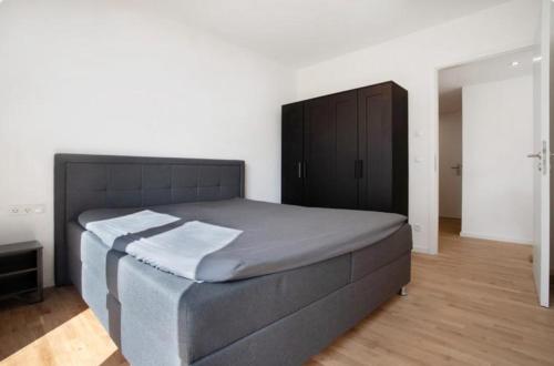 a bedroom with a large bed and a black cabinet at Top Loft mit Gartenterrasse in Greifswald