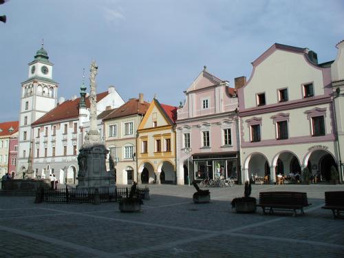 ein Stadtplatz mit Gebäuden und einem Uhrturm in der Unterkunft Apartmány Reve in Třeboň