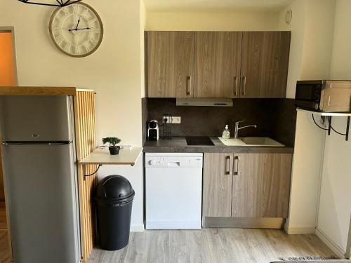 Il comprend une cuisine équipée d'un réfrigérateur et d'une horloge murale. dans l'établissement Appartement Sainte Maxime, à Sainte-Maxime