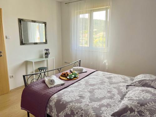 a bedroom with a bed with a tray of food on it at Apartment Leonora in Vinišće