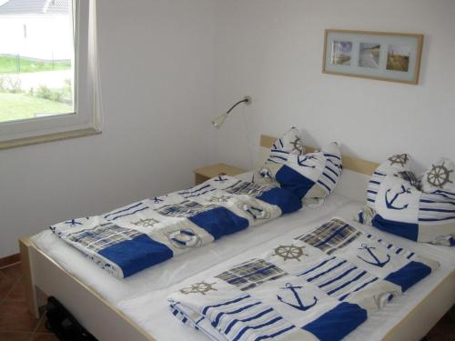 ニーンハーゲンにあるFH Strandperlchenのベッド2台(青と白の毛布、枕付)