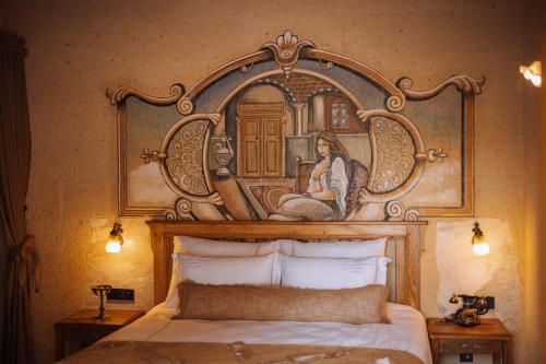 a bedroom with a painting above a bed at The Kingdom Of Cappadocia Luxury Cave Hotel in Uchisar