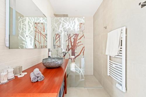 La salle de bains est pourvue d'un comptoir en bois et d'un lavabo. dans l'établissement La Méditerranée à vos pieds - Vue & Accès, à Carqueiranne