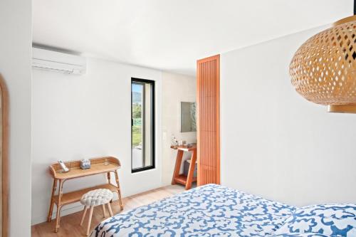 une chambre avec un lit, une table et une fenêtre dans l'établissement La Méditerranée à vos pieds - Vue & Accès, à Carqueiranne