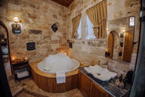 a bathroom with a bath tub and a sink at The Kingdom Of Cappadocia Luxury Cave Hotel in Uchisar
