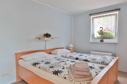 a bedroom with a bed with a black and white comforter at FeWo Lavendel in Kröpelin