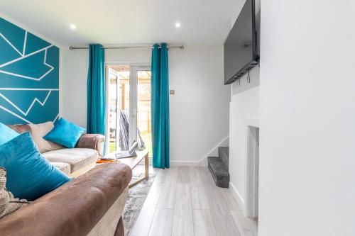 a living room with blue curtains and a couch at Newly Refurbed, Driveway, 4-BR House, Ensuite in Northampton