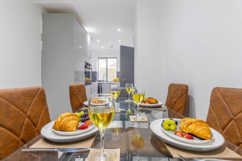 a table with plates of food and glasses of wine at Newly Refurbed, Driveway, 4-BR House, Ensuite in Northampton