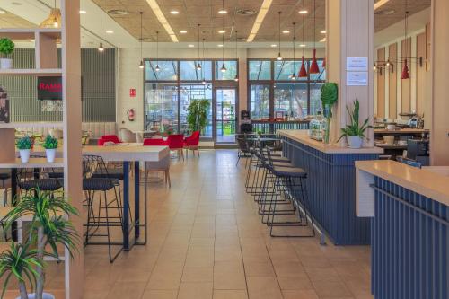 a restaurant with tables and chairs and a cafeteria at Ramada by Wyndham Madrid Getafe in Getafe