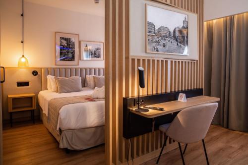 a hotel room with a bed and a desk at Ramada by Wyndham Madrid Getafe in Getafe