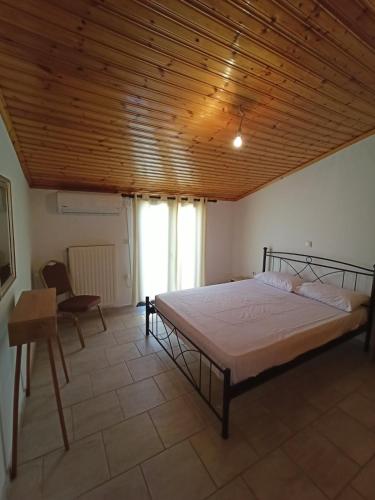 a bedroom with a bed and a wooden ceiling at Poseidon home in Ireo, by the sea in Iraion