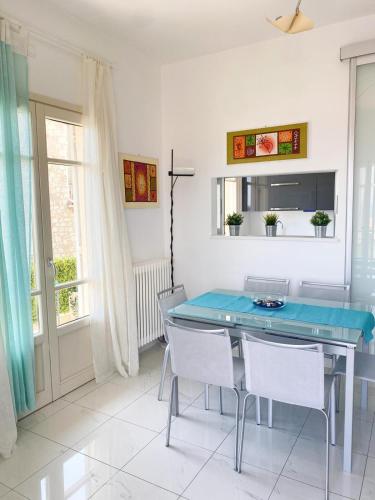 une salle à manger avec une table et des chaises bleues dans l'établissement Appartamento vista mare, à Saint-Jean-Cap-Ferrat