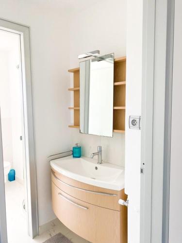 une salle de bain avec un lavabo et un miroir dans l'établissement Appartamento vista mare, à Saint-Jean-Cap-Ferrat
