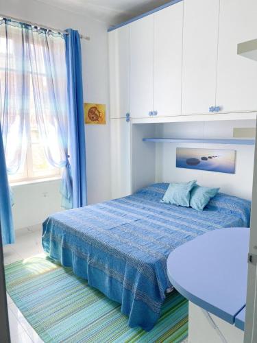 - une chambre avec un lit bleu et une table dans l'établissement Appartamento vista mare, à Saint-Jean-Cap-Ferrat