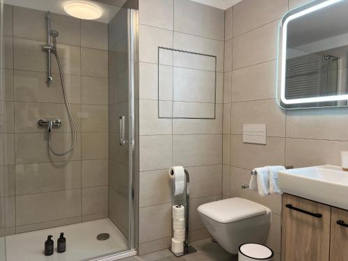 a bathroom with a shower and a toilet and a sink at SIA Apartment in Dolní Morava
