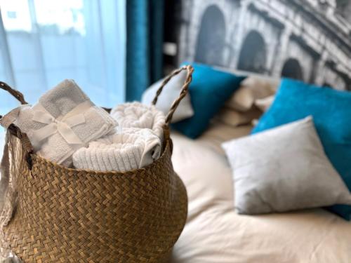 a basket sitting on top of a couch with pillows at Labicum XXII - Modern Luxury Studio near the Colosseum in Rome