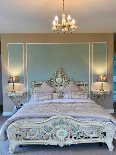 a bedroom with a large bed with a chandelier at Rossmanagher House in Bunratty