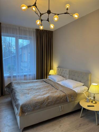 a bedroom with a bed and a large window at DHARMA Stay Notaro apartamentai Self check-in in Telšiai