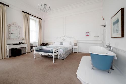 a bedroom with a tub and a bed and a tub at Aston Hall Hotel, BW Signature Collection in Sheffield