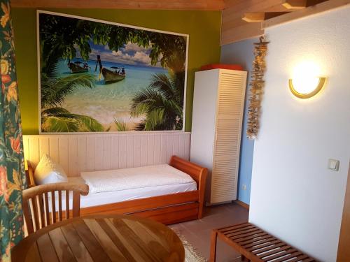 a small room with a bed and a painting on the wall at Cafe und Pension am Rennsteig in Blankenstein