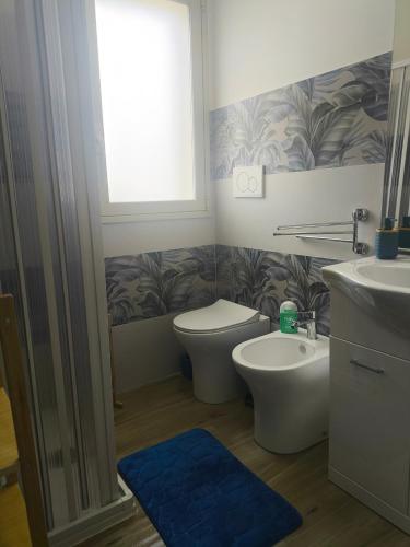 a bathroom with a toilet and a sink and a window at Blue Flowers Room in Scordia