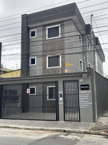 a building with a gate in front of it at Hachi Flats - GRU in Guarulhos