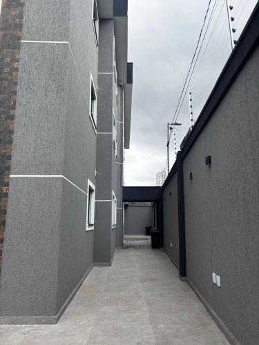 an alleyway between two buildings with a garage at Hachi Flats - GRU in Guarulhos