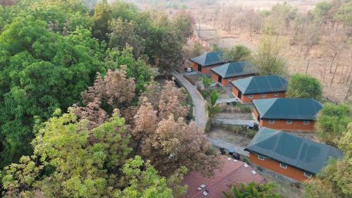 an overhead view of a row of houses in a forest at Nehamrit Farmstays with Pool, Near Malshej Ghat in Murbād