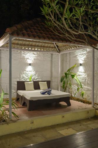 a bed in a gazebo on a deck at Nehamrit Farmstays with Pool, Near Malshej Ghat in Murbād