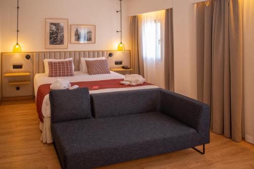a bedroom with a large bed and a couch at Ramada by Wyndham Madrid Getafe in Getafe