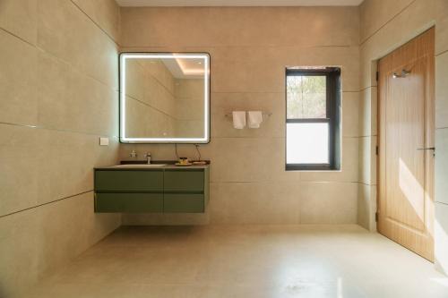 a bathroom with a green sink and a mirror at Nehamrit Farmstays with Pool, Near Malshej Ghat in Murbād