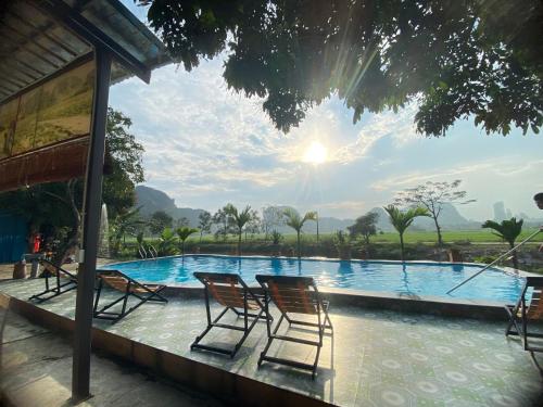 a group of chairs sitting next to a swimming pool at Tam Coc Moutainside Homestay in Ninh Binh