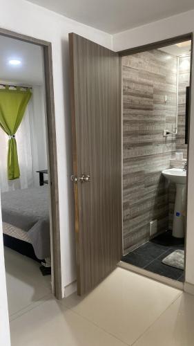 a bathroom with a mirror and a bed and a sink at Tunja Magic Habitación in Tunja