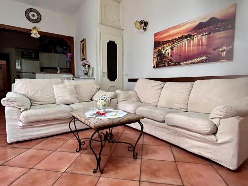 a living room with two white couches and a table at Maison Coppola in Vico Equense