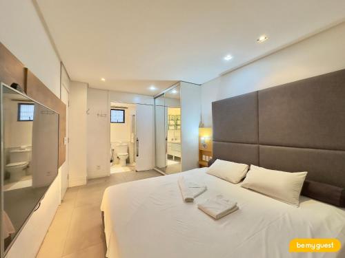 a bedroom with a large white bed and a bathroom at Hotel na Beira Mar de Fortaleza in Fortaleza