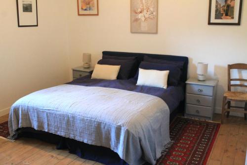 a bedroom with a bed with a blue comforter at Cha16 - Nanteuil En Vallee - Touchbaudrand in Messeux
