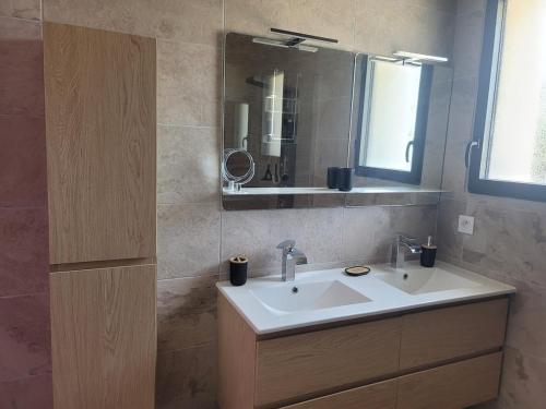 une salle de bain avec un lavabo et un miroir dans l'établissement ONLY YOU option spa, sauna et piscine, à Castelsarrasin