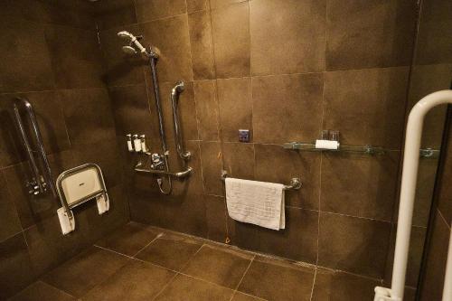 a bathroom with a shower with a white towel at The Vincent Hotel in Southport