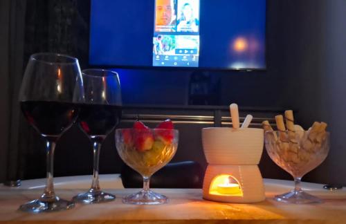 a table with three glasses of wine and a candle at Cabana Ninho do Quero-Quero in Campo Largo