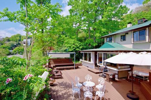 a house with a deck with chairs and a piano at ペンション城ケ崎 in Ito