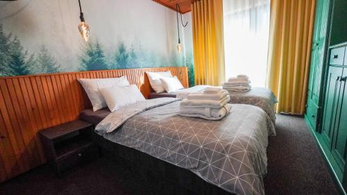 two beds in a hotel room with towels on them at Hiša na Hribu- A Peaceful Hilltop Escape above river Kolpa in Kostel