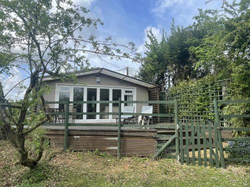 a home with a fence and a house at New Forest 2 bedroom Guest Suite & Hot Tub in Ibsley