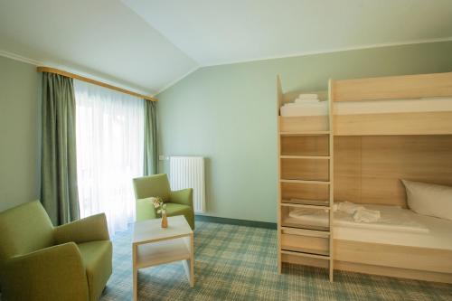 a bedroom with a bunk bed and a chair at Ferien Hotel Spree-Neisse in Neuhausen