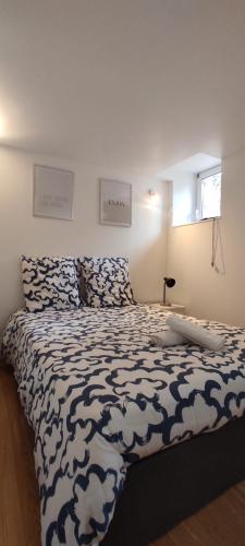 une chambre avec un lit avec une couette noire et blanche dans l'établissement L'Atelier Gauthier, à Cholet