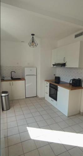 Il comprend une cuisine avec des appareils électroménagers blancs et du carrelage. dans l'établissement L'Atelier Gauthier, à Cholet