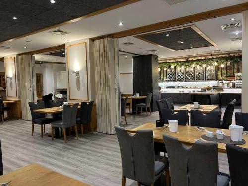 a restaurant with wooden tables and chairs and a bar at Hotel am Rugard in Bergen auf Rügen