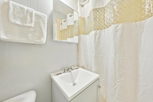 a white bathroom with a sink and a toilet at Flint Motel by OYO MI Near I-475 in Flint