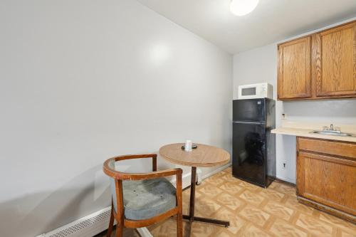 a small kitchen with a table and a refrigerator at Flint Motel by OYO MI Near I-475 in Flint