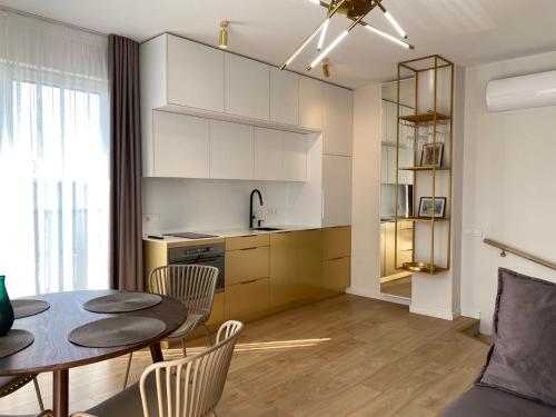 a kitchen and dining room with a table and chairs at GOLD apartment / Mano jūra 3 in Kunigiškiai