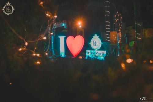 a red heart is on a sign with lights at PRIME MURTI RESORT and SPA in Chālsa Mahābāri
